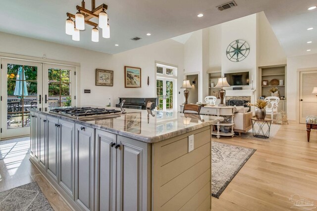 kitchen with light stone countertops, french doors, a center island, and a healthy amount of sunlight