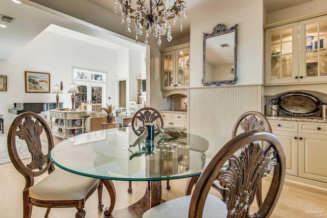 dining area featuring a notable chandelier and light wood-type flooring