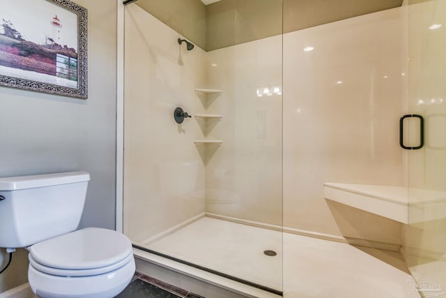 bathroom with toilet and a shower with shower door