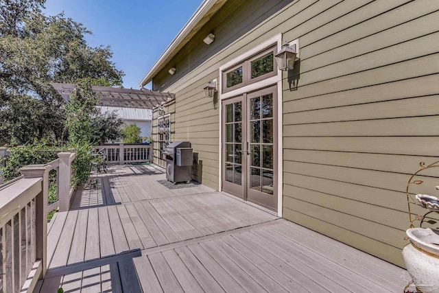 wooden deck featuring a grill, a pergola, and french doors