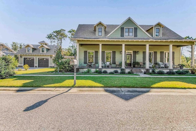 view of front facade featuring covered porch, a front yard, and a garage