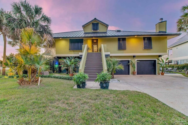 4552 Bayside Dr, Milton, FL 32583 - coastal home with an attached garage, stairway, metal roof, driveway, and a standing seam roof