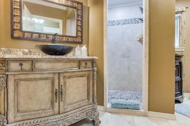 4552 Bayside Dr, Milton, FL 32583 - bathroom with a tile shower, tile patterned floors, vanity, and baseboards