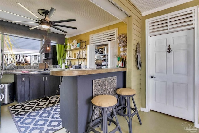 4552 Bayside Dr, Milton, FL 32583 - kitchen with ceiling fan, wood walls, ornamental molding, a kitchen breakfast bar, and a sink