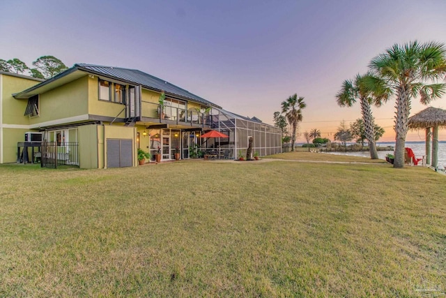 4552 Bayside Dr, Milton, FL 32583 - view of yard featuring glass enclosure, a water view, and a garage