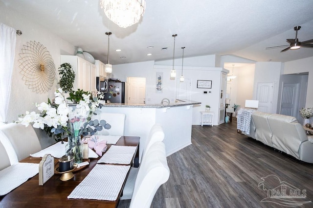 kitchen featuring lofted ceiling, dark wood-type flooring, ceiling fan with notable chandelier, and white cabinets