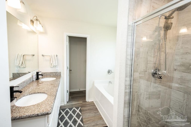 bathroom featuring dual vanity, wood-type flooring, and independent shower and bath