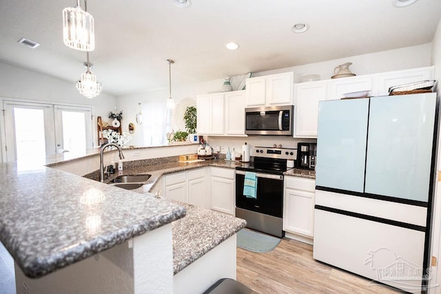 kitchen with stainless steel appliances, sink, white cabinetry, light hardwood / wood-style floors, and decorative light fixtures