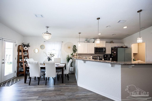 kitchen featuring dark hardwood / wood-style floors, stainless steel appliances, white cabinetry, and a wealth of natural light