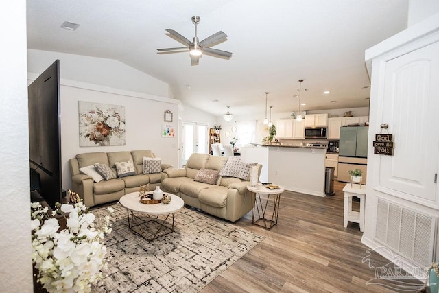 living room with ceiling fan, wood-type flooring, and lofted ceiling