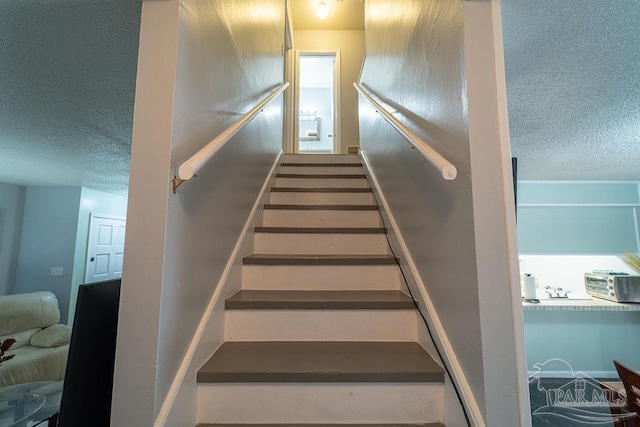 staircase with a textured ceiling