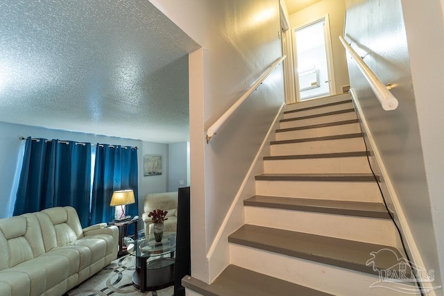 staircase with a textured ceiling