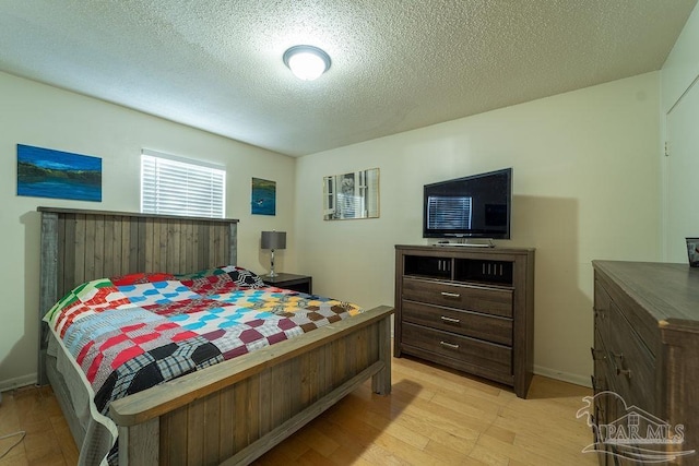 bedroom with light hardwood / wood-style flooring and a textured ceiling