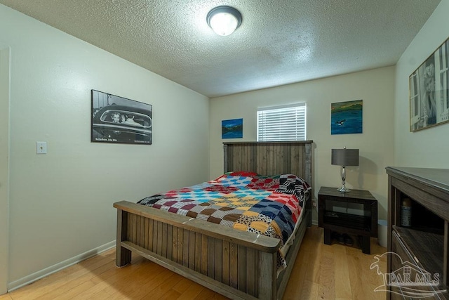 bedroom with light hardwood / wood-style floors and a textured ceiling