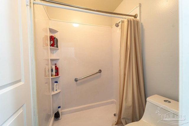 bathroom featuring a shower with curtain and toilet