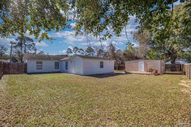 rear view of house with a yard and an outbuilding