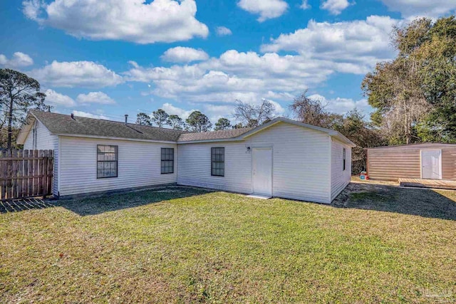 back of property featuring a yard and a shed