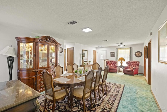 dining area featuring carpet flooring and a textured ceiling