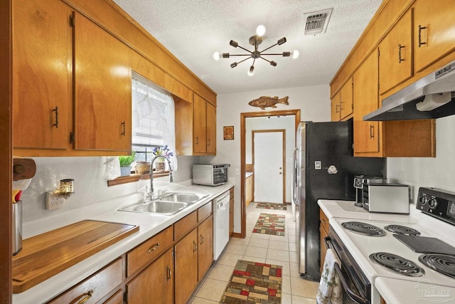 kitchen with sink, an inviting chandelier, a textured ceiling, white appliances, and light tile patterned floors