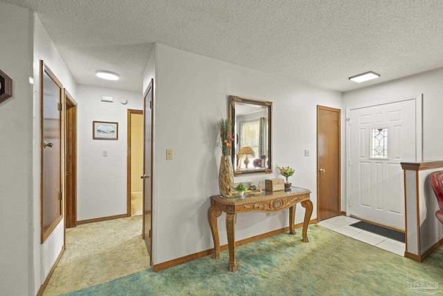 carpeted foyer with a textured ceiling