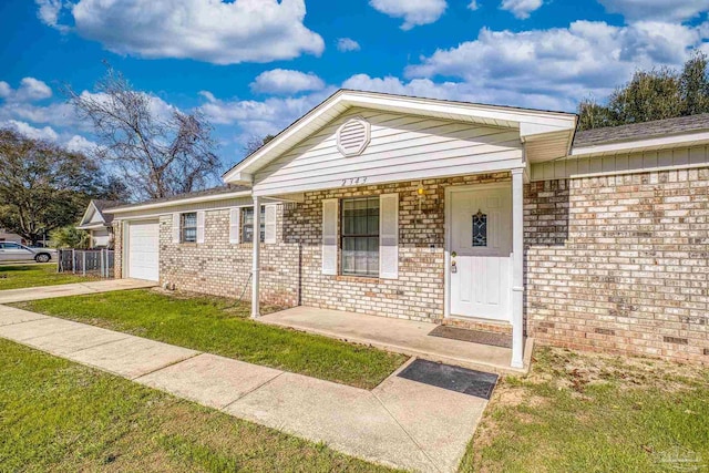 view of front of house featuring covered porch, a garage, and a front lawn