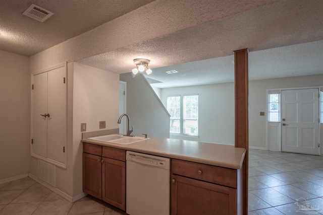 kitchen featuring light tile patterned flooring, dishwasher, sink, kitchen peninsula, and a textured ceiling