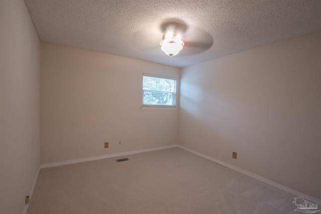 carpeted empty room with a textured ceiling