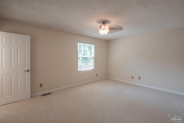 unfurnished room with light carpet and a textured ceiling