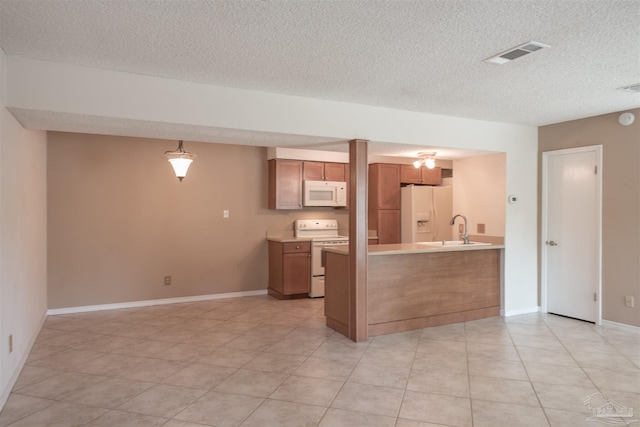 kitchen with sink, a textured ceiling, light tile patterned floors, kitchen peninsula, and white appliances