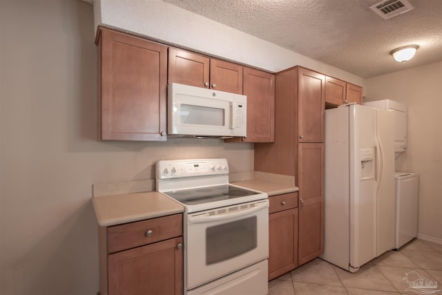 kitchen featuring separate washer and dryer, light tile patterned floors, white appliances, and a textured ceiling