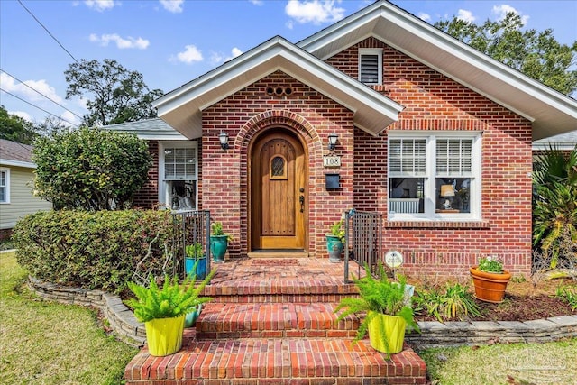 doorway to property featuring brick siding