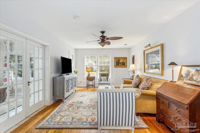 living area featuring light wood-style floors and a ceiling fan