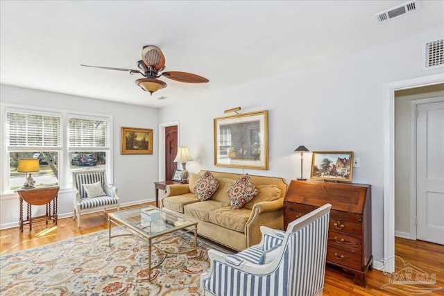 living room featuring visible vents, ceiling fan, and wood finished floors