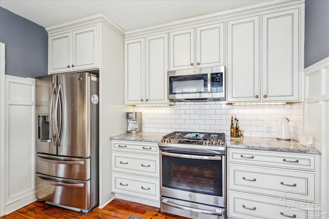 kitchen with appliances with stainless steel finishes, decorative backsplash, and light stone counters