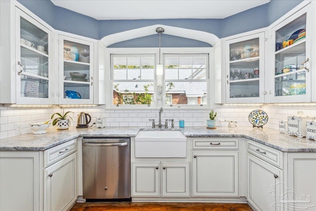 kitchen featuring a sink, light stone counters, decorative backsplash, and dishwasher