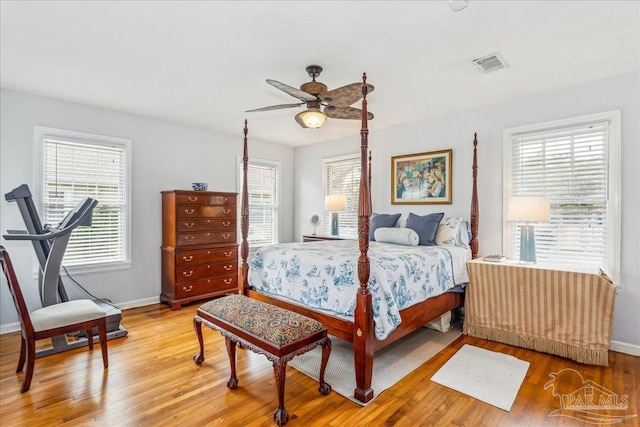 bedroom with light wood-style floors, visible vents, baseboards, and multiple windows