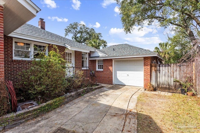 view of front of house with a garage, brick siding, fence, driveway, and a chimney