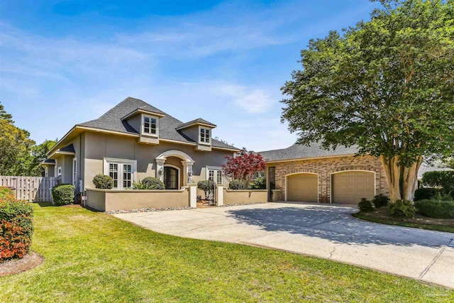 view of front of home featuring fence, a front lawn, stucco siding, driveway, and roof with shingles