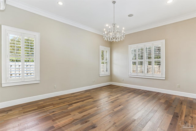 empty room featuring baseboards, dark wood-style floors, ornamental molding, and an inviting chandelier