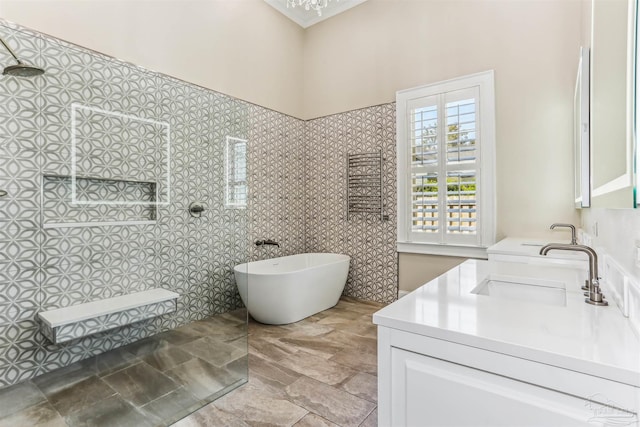 bathroom featuring a freestanding tub, stone finish floor, vanity, and a walk in shower