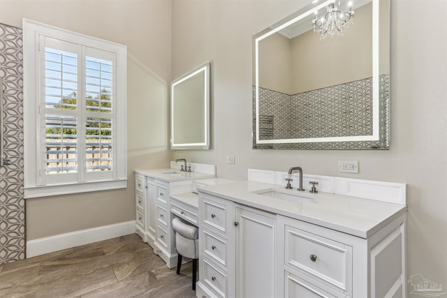 full bathroom featuring a shower, baseboards, vanity, and a notable chandelier