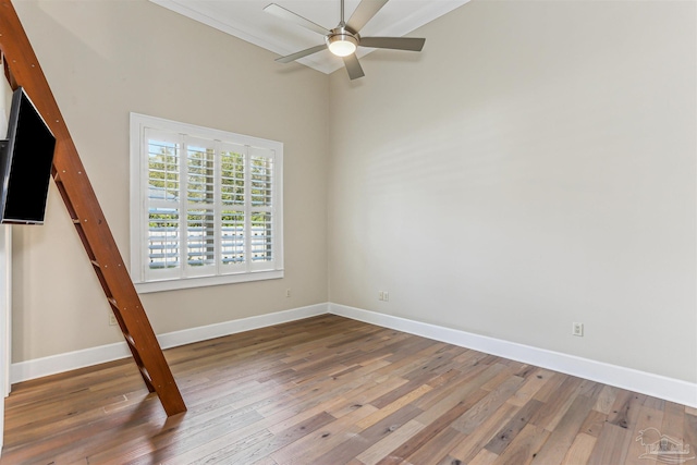 empty room featuring baseboards, a ceiling fan, and wood finished floors