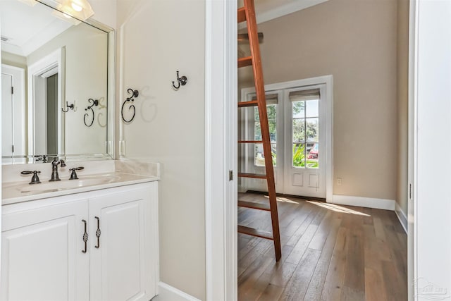 bathroom with hardwood / wood-style flooring, baseboards, and vanity
