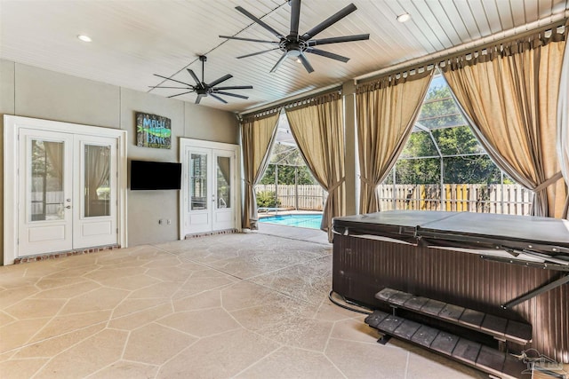 sunroom with a hot tub, ceiling fan, and french doors