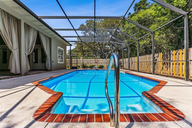 view of swimming pool with a fenced backyard, a patio, a fenced in pool, and glass enclosure