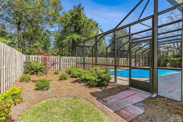 view of pool with a fenced backyard, a fenced in pool, and glass enclosure