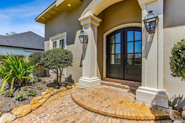 property entrance featuring french doors and stucco siding