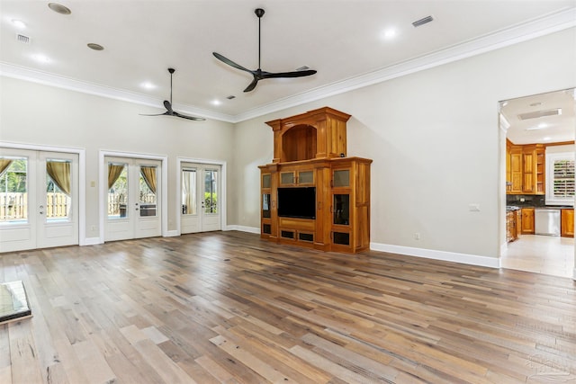 unfurnished living room with crown molding, ceiling fan, french doors, light wood-style flooring, and visible vents