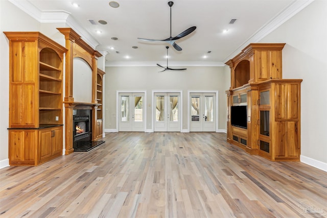 unfurnished living room with crown molding, ceiling fan, a lit fireplace, light wood finished floors, and baseboards