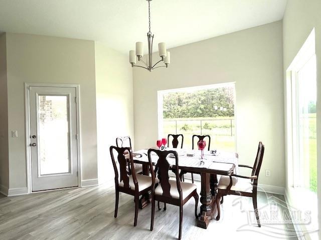 dining space featuring plenty of natural light, a notable chandelier, and light hardwood / wood-style flooring